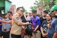Pj Gubernur Jawa Timur, Adhy Karyono, saat meninjau lokasi banjir di Kabupaten Pasuruan sekaligus membagikan bantuan, Sabtu (7/12/2024).