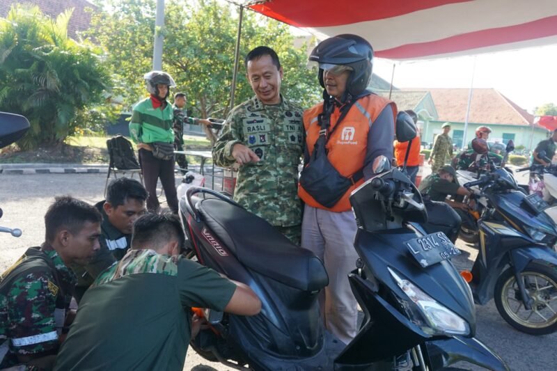 Kapaldam V/Brawijaya Kolonel Cpl Ir Ahmad Rasli, bersama pengemudi ojol yang mengikuti kegiatan ganti oli gratis. (Foto: T1/Ist)